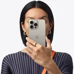 Osoba trzymająca iPhone’a 15 Pro Max przed twarzą