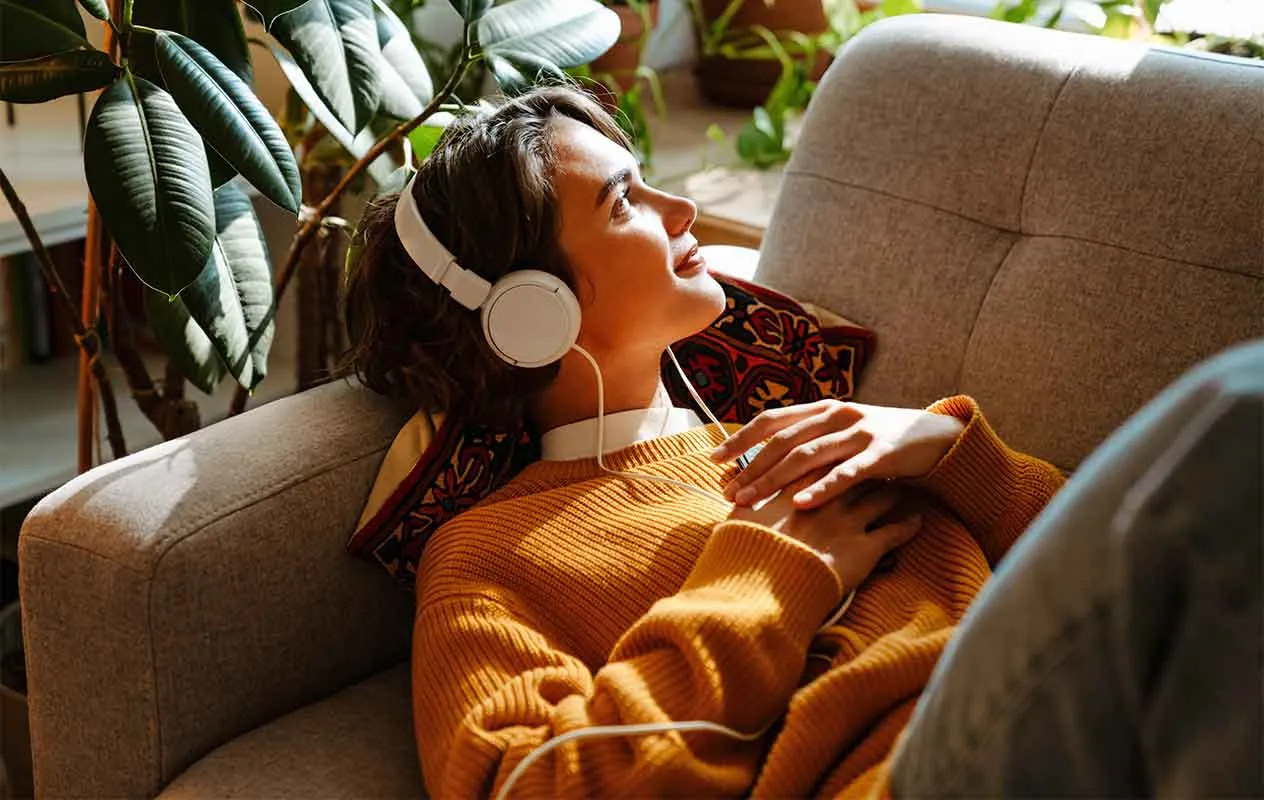młoda kobieta słucha muzyki na sofie