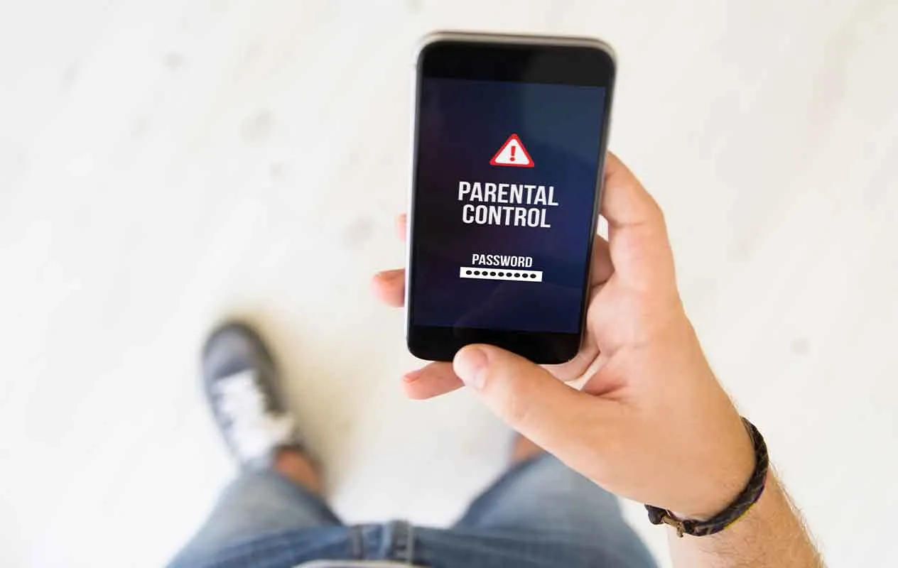 osoba trzyma telefon z aplikacją do kontroli rodzicielskiej