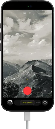 iPhone 18 Pro, przód obudowy, na ekranie górski krajobraz z nakładką trybu aparatu w Trybie poklatkowym, przewód zasilający podłączony do portu ładowania