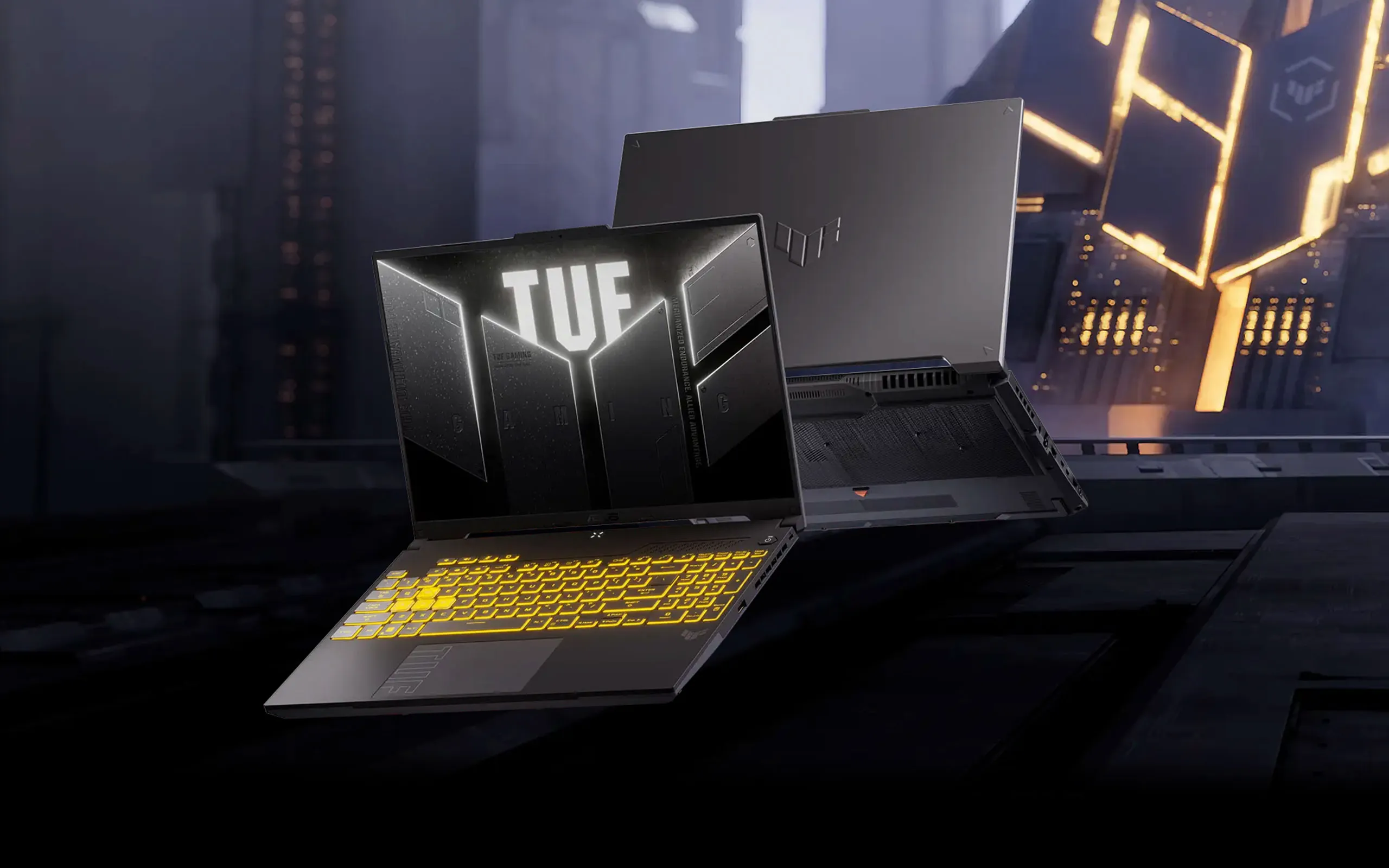 Laptop gamingowy ASUS TUF z podświetlaną klawiaturą na żółto i wyświetlaczem z logo TUF, widok z przodu i z tyłu na futurystycznym tle.
