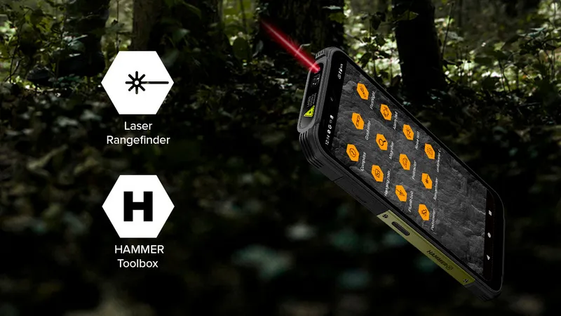 Wytrzymały smartfon z funkcją dalmierza laserowego, widoczną jako czerwony promień emitowany z górnej części urządzenia. Na ekranie telefonu znajdują się ikony aplikacji w pomarańczowym kolorze. Po lewej stronie widoczne są dwie sześciokątne ikony: jedna z symbolem lasera i napisem Laser Rangefinder, druga z literą H i napisem HAMMER Toolbox. Tło stanowi leśne otoczenie.