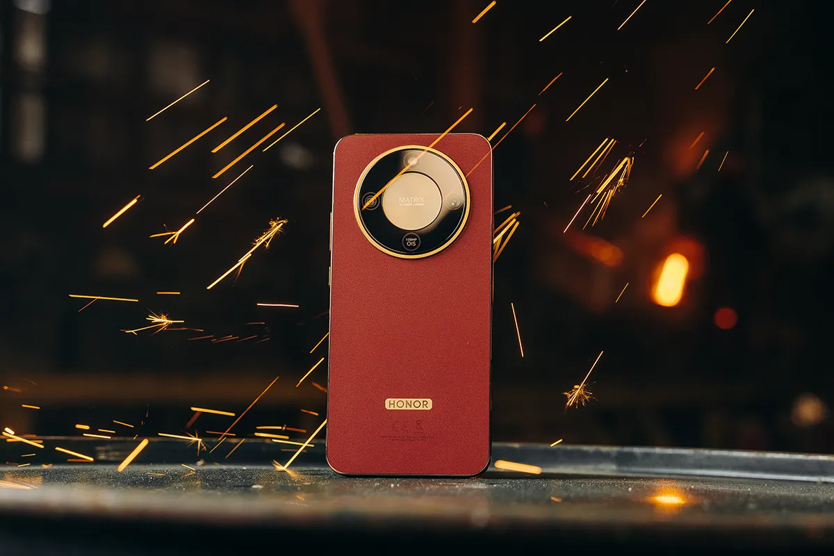 HONOR Magic 8 Lite w kolorze brązowym stojący wśród iskier ze spawarki