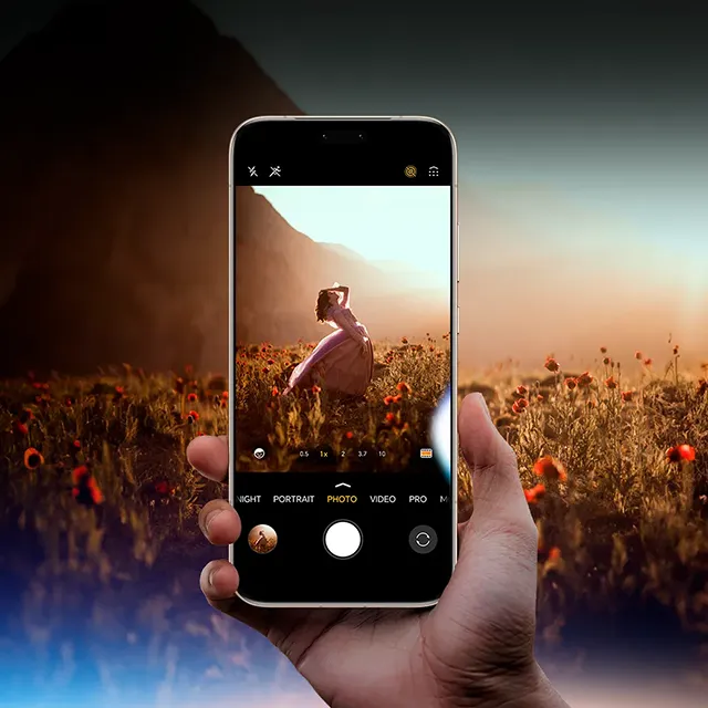 Smartfon trzymany w dłoni na tle łąki z widocznym przyciskiem AI