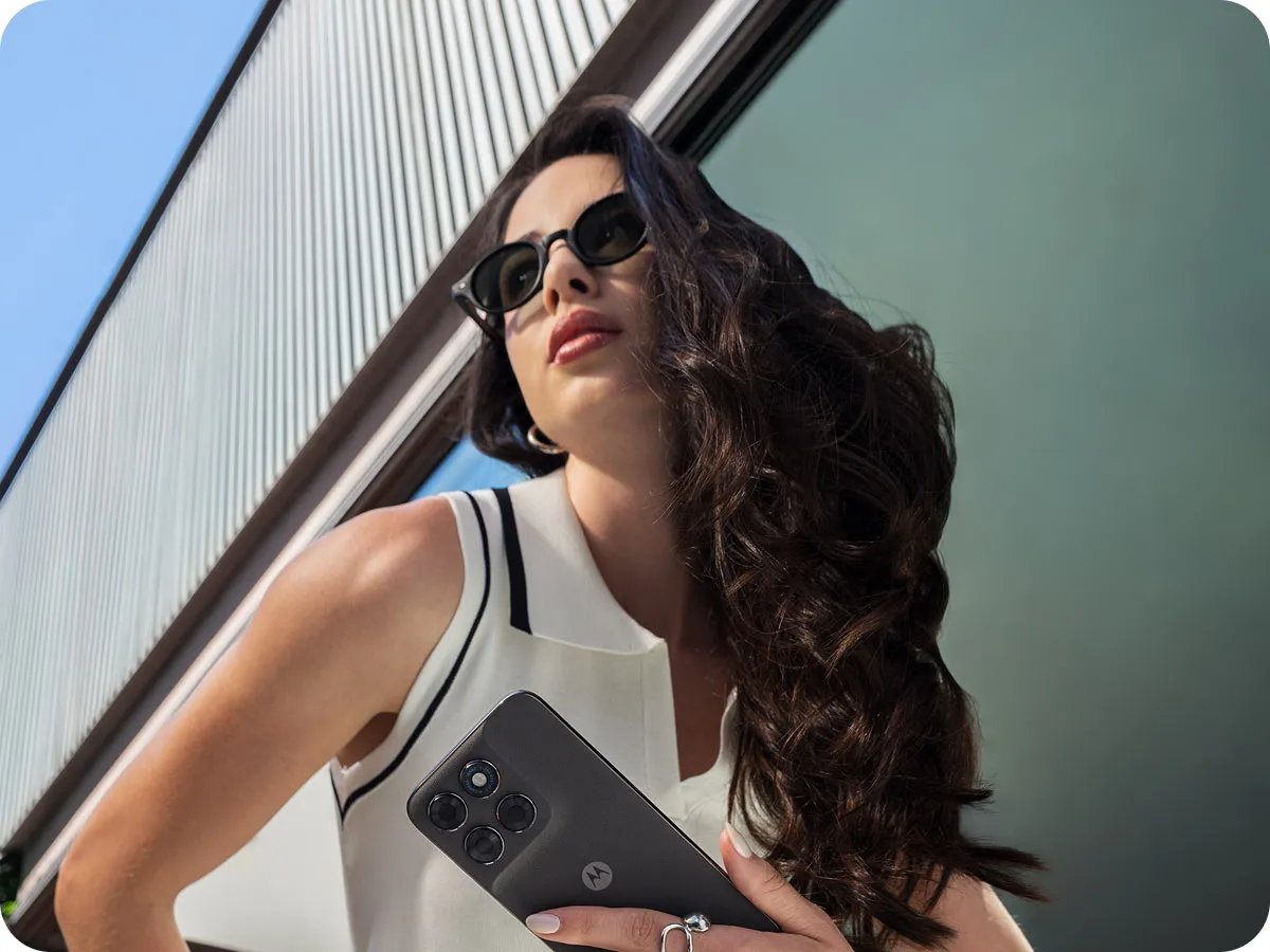 Kobieta w okularach przeciwsłonecznych trzyma ciemny smartfon moto g77 przy twarzy