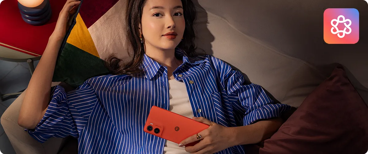 Kobieta relaksująca się na kanapie z czerwonym smartfonem Motorola moto g06 POWER