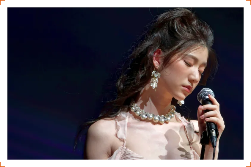 Portret kobiety śpiewającej do mikrofonu na tle ciemnego tła, elegancka biżuteria