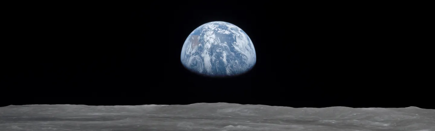 Widok Ziemi wyłaniającej się nad powierzchnią Księżyca w czarnej przestrzeni kosmicznej