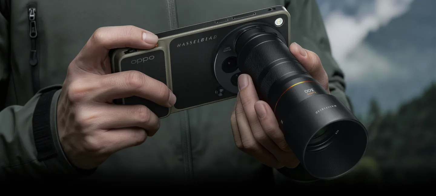 Smartfon OPPO z doczepionym teleobiektywem Hasselblad 300 mm trzymany w dłoniach