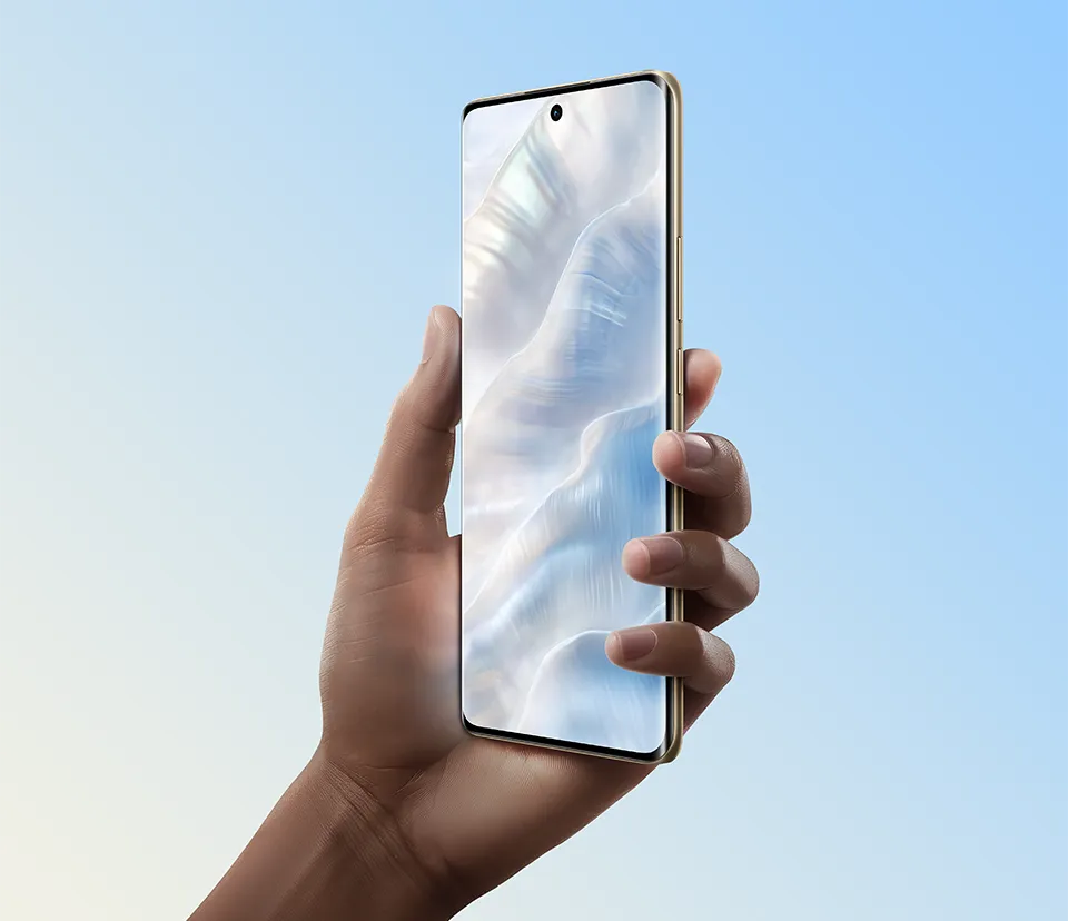 Ręka trzyma smartfon z dużym ekranem zajmującym niemal całą przednią powierzchnię. Na wyświetlaczu widoczny abstrakcyjny, falisty wzór w jasnych kolorach. U góry ekranu znajduje się niewielki okrągły otwór, prawdopodobnie na przedni aparat. Tło w odcieniach jasnego błękitu i bieli.