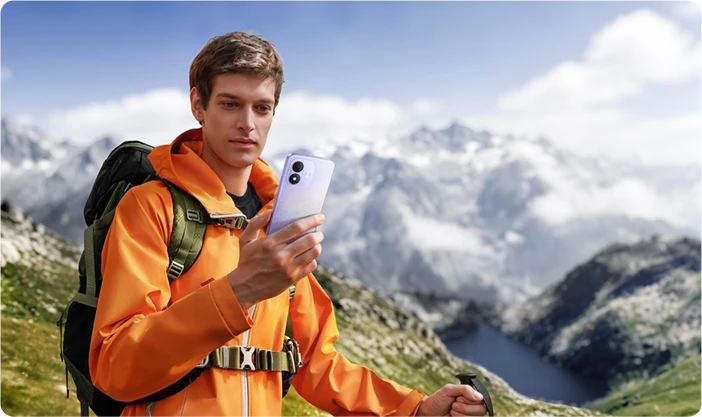Mężczyzna z plecakiem korzystający z REDMI Note 17 podczas górskiej wędrówki