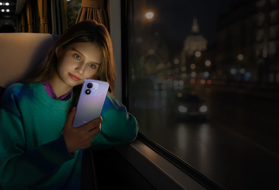 Kobieta korzystająca z fioletowego smartfona podczas nocnej podróży autobusem