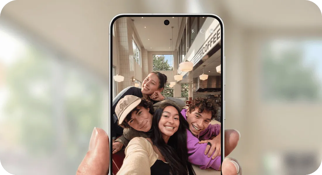 Czworo znajomych robi grupowe selfie przednim aparatem smartfona Galaxy.
