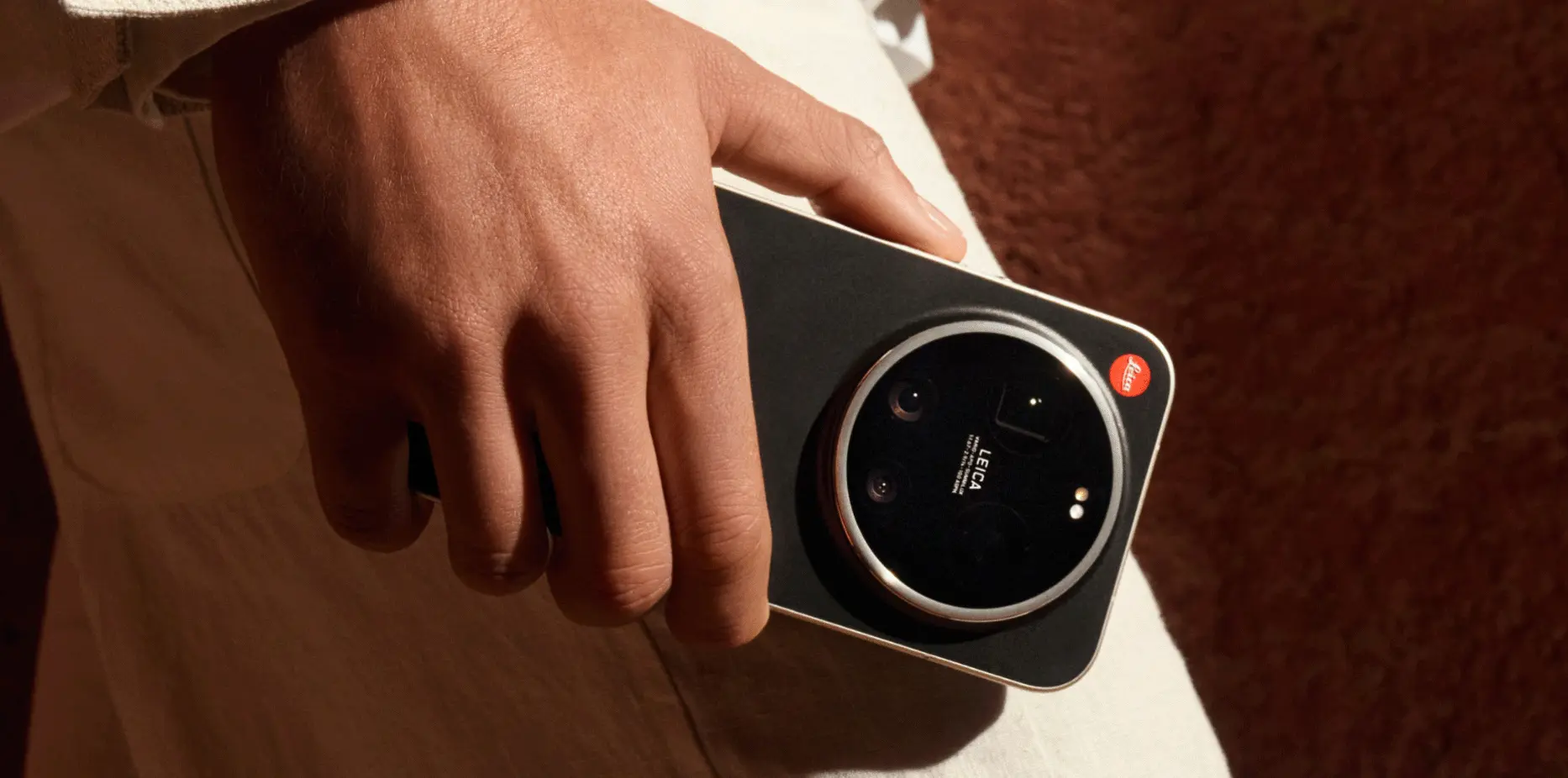 Zbliżenie dłoni trzymającej Leitzphone z widocznym modułem aparatu Leica
