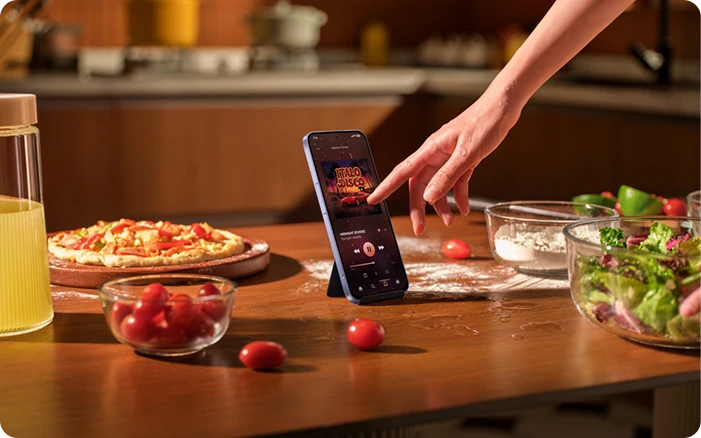 Osoba obsługująca smartfon REDMI mokrą dłonią podczas przygotowywania posiłku