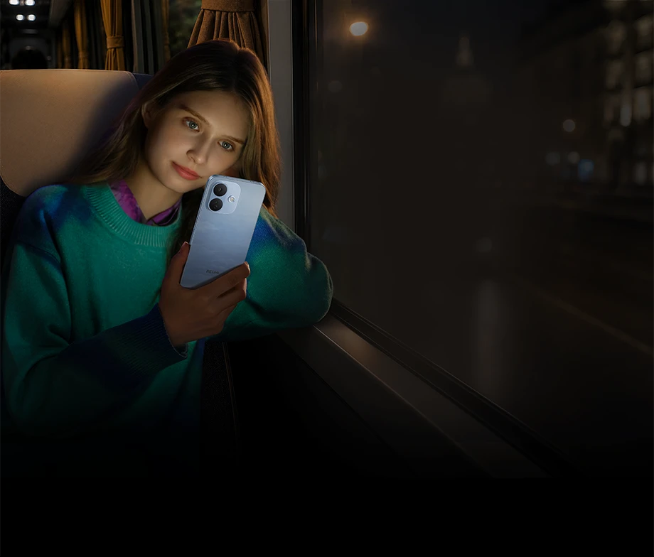 Kobieta trzymająca jasnoniebieski smartfon REDMI podczas nocnej podróży