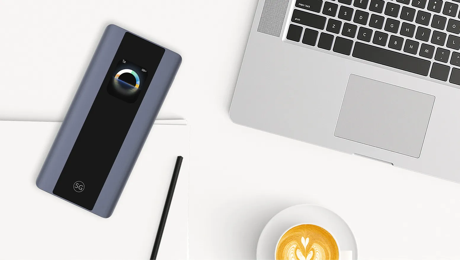 Mobilny router Zowee 5G leżący na biurku obok laptopa, notesu i filiżanki kawy.